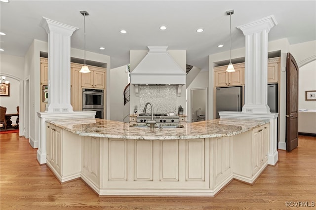 kitchen featuring appliances with stainless steel finishes, cream cabinets, light stone counters, and light hardwood / wood-style floors