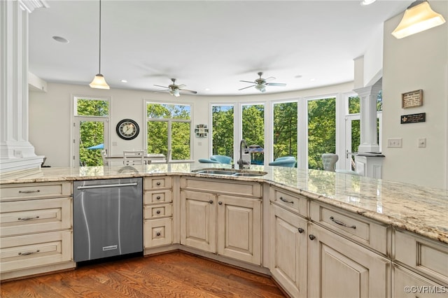 kitchen featuring stainless steel dishwasher, sink, ornate columns, and dark hardwood / wood-style flooring