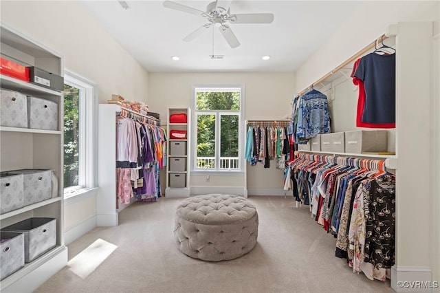 spacious closet with light carpet and ceiling fan