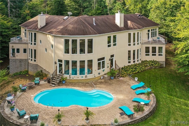 back of property with a patio area, a lawn, and a balcony