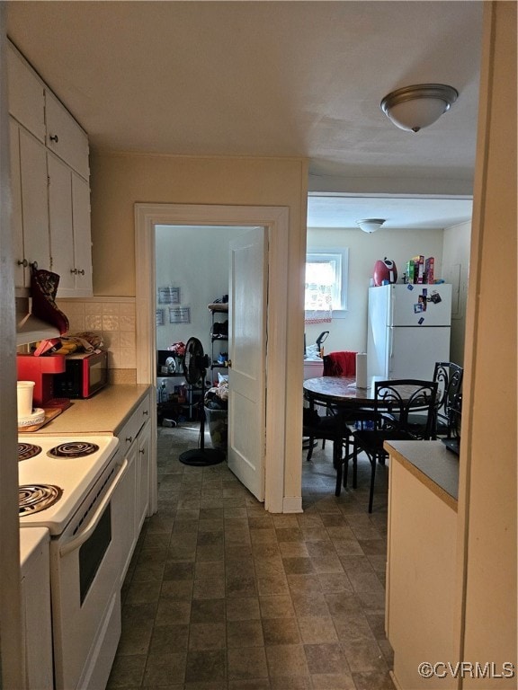 kitchen featuring decorative backsplash, white cabinetry, and white appliances