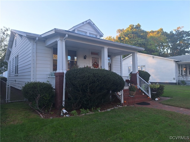 bungalow featuring a front lawn and a porch