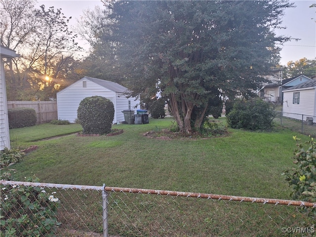 yard at dusk featuring a storage shed