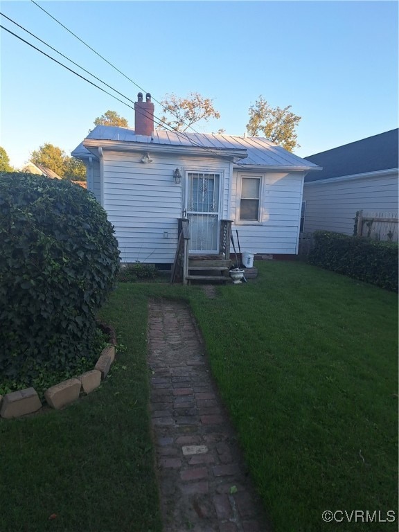 rear view of house featuring a yard