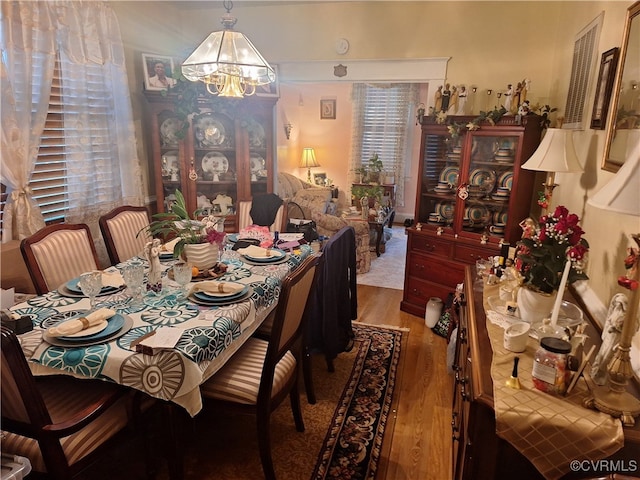 dining space featuring hardwood / wood-style floors and a chandelier