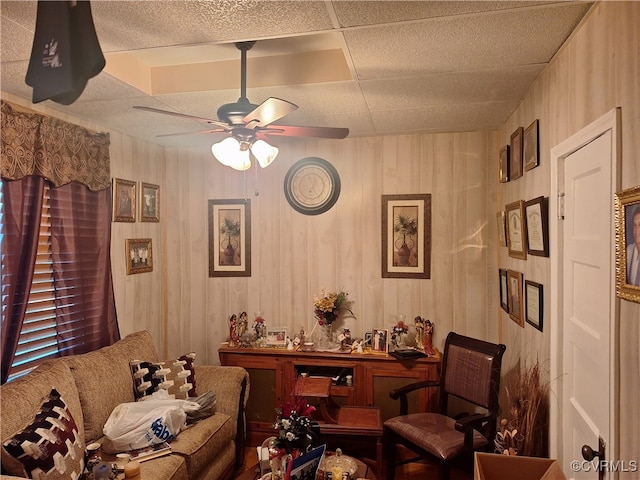 living room featuring a paneled ceiling and ceiling fan