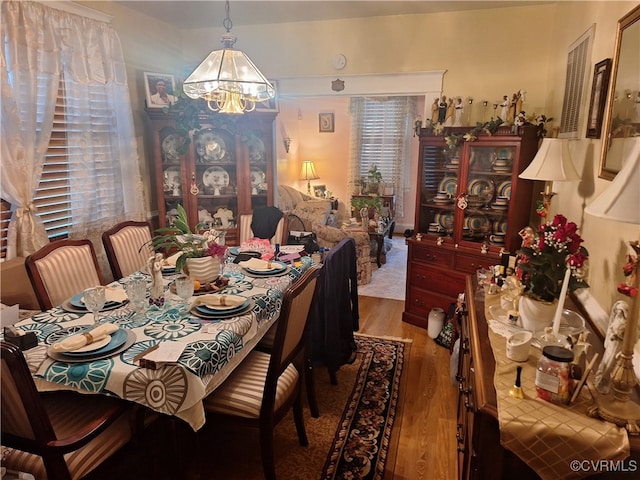 dining area featuring wood-type flooring and an inviting chandelier