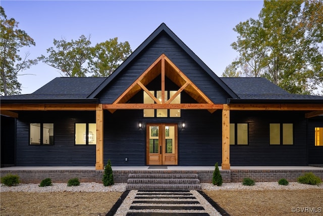 view of front of property with a porch and roof with shingles