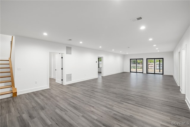 unfurnished living room with recessed lighting, visible vents, and stairs