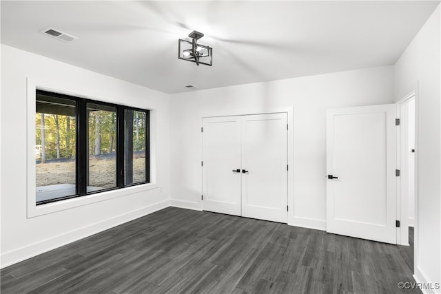 interior space featuring dark wood-type flooring, visible vents, and baseboards