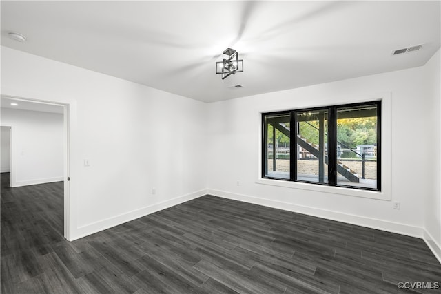 spare room with dark wood-style floors, baseboards, and visible vents