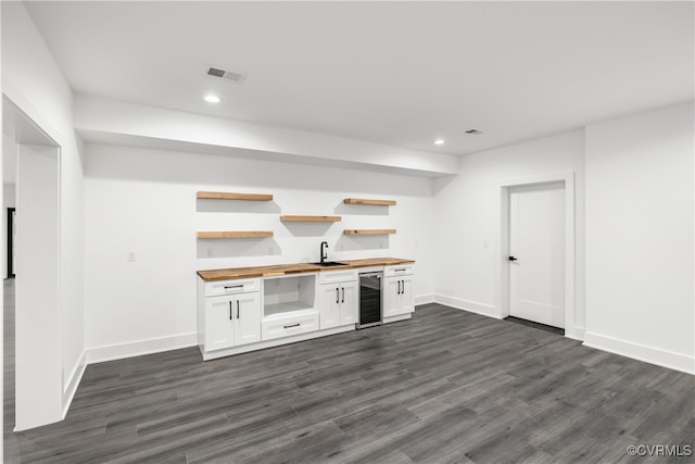 bar with beverage cooler, dark wood-type flooring, visible vents, and recessed lighting