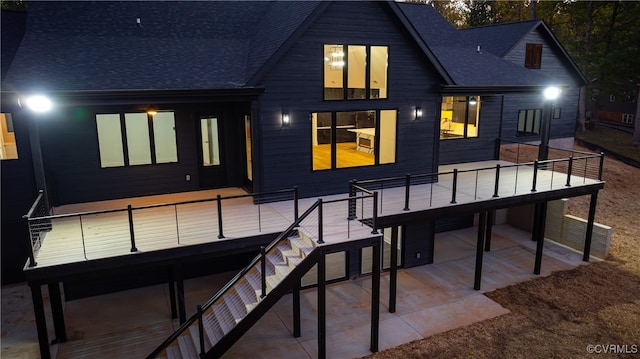 back of property featuring stairs, a patio area, a wooden deck, and roof with shingles