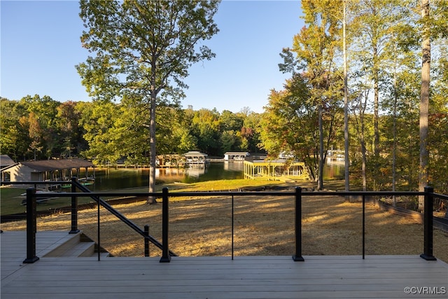 wooden deck with a dock and a water view