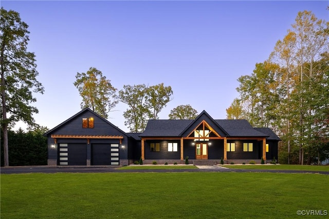 modern farmhouse with a front lawn, driveway, and an attached garage