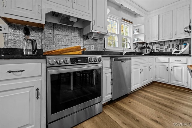 kitchen featuring stainless steel appliances, white cabinetry, backsplash, sink, and hardwood / wood-style floors