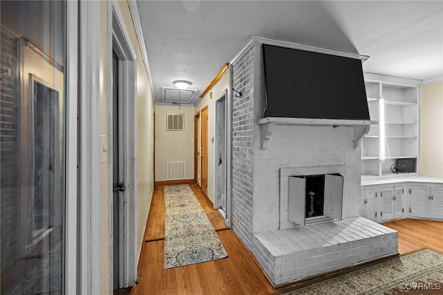 hall with light wood-type flooring and ornamental molding