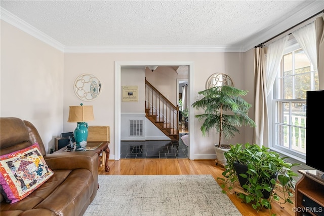 sitting room with crown molding, wood-type flooring, and a textured ceiling