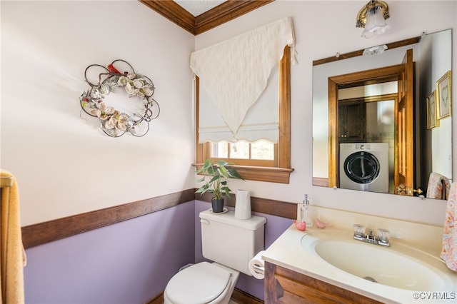 bathroom featuring vanity, toilet, ornamental molding, and washer / clothes dryer