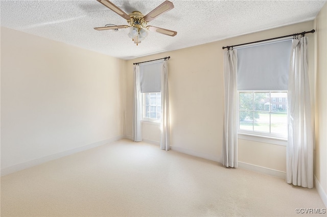 spare room featuring a textured ceiling, light colored carpet, and ceiling fan