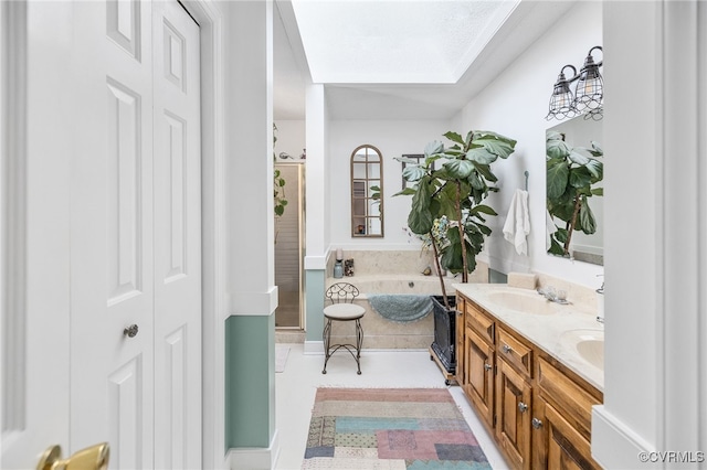 bathroom featuring separate shower and tub, a skylight, tile patterned flooring, and vanity