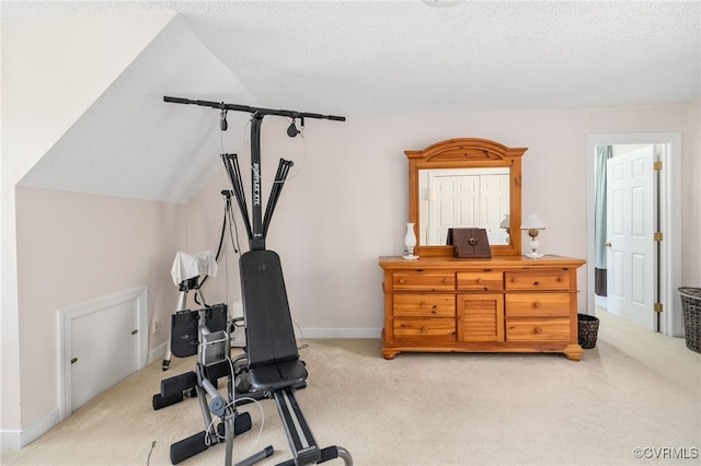 exercise room with light carpet, a textured ceiling, and lofted ceiling