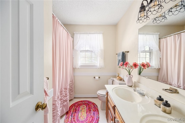 bathroom with plenty of natural light, toilet, a textured ceiling, and vanity