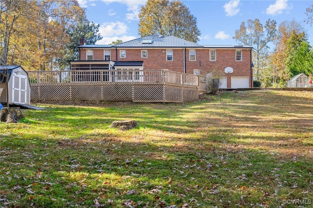 rear view of property featuring a shed, a garage, a lawn, and a wooden deck