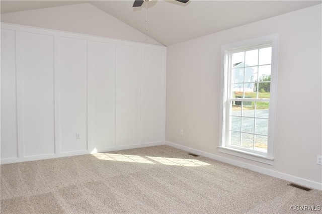 spare room with ceiling fan, light carpet, and vaulted ceiling