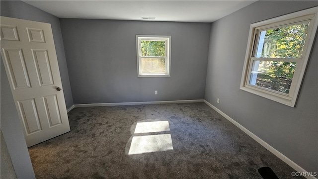 unfurnished room featuring dark carpet