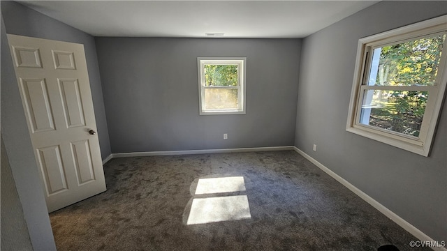 unfurnished room featuring dark carpet