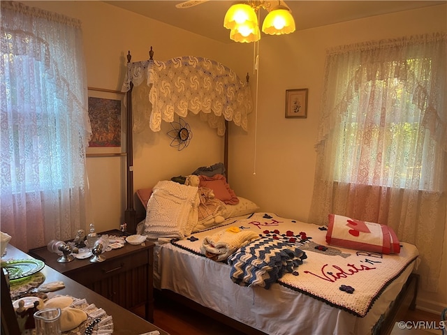 bedroom with multiple windows and hardwood / wood-style flooring