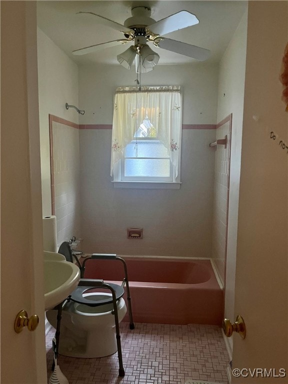 bathroom featuring tiled shower / bath combo, toilet, and ceiling fan