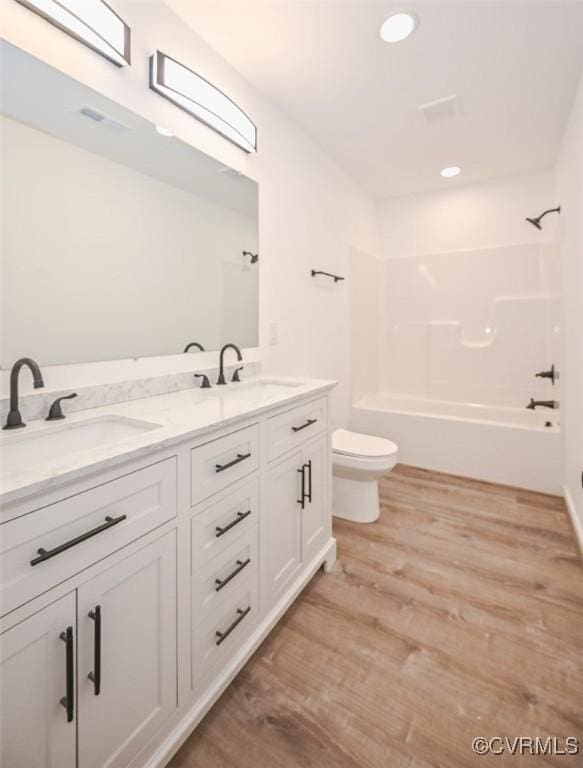 full bathroom featuring vanity, toilet, tub / shower combination, and hardwood / wood-style floors