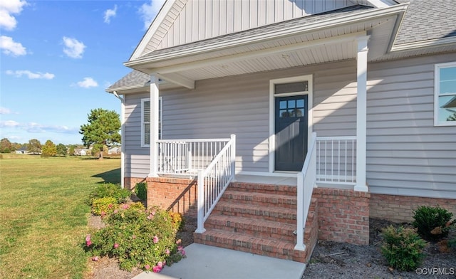 entrance to property featuring a yard and a porch