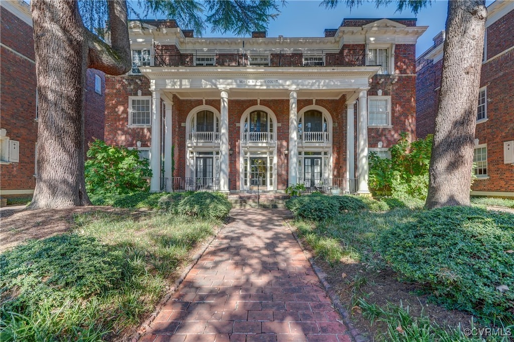 view of exterior entry featuring a balcony