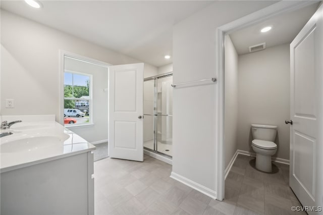 bathroom featuring vanity, a shower with shower door, and toilet