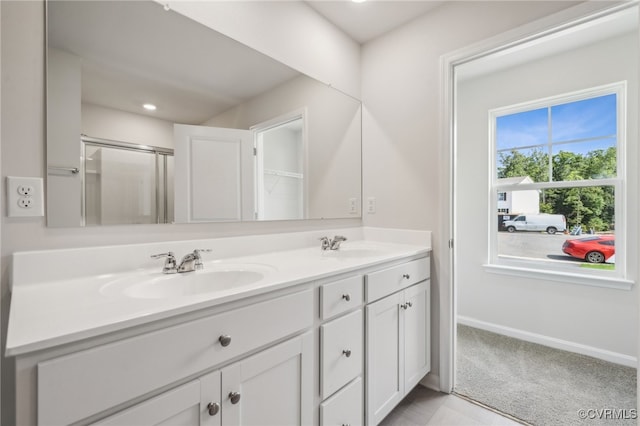 bathroom with vanity and a shower with door