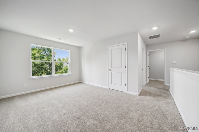 spare room featuring light carpet