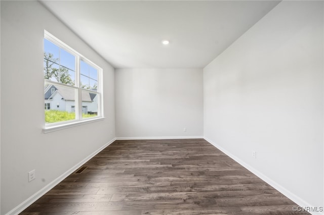 spare room featuring dark wood-type flooring