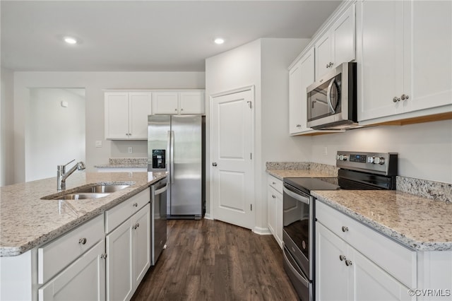 kitchen with sink, stainless steel appliances, dark hardwood / wood-style floors, white cabinets, and a center island with sink