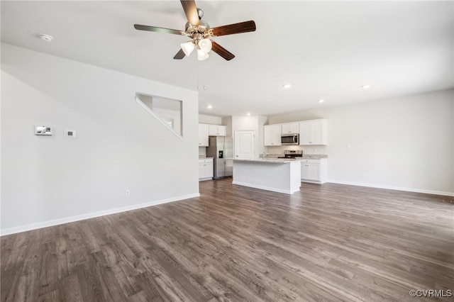 unfurnished living room with dark hardwood / wood-style floors and ceiling fan