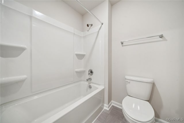 bathroom with tile patterned floors, bathing tub / shower combination, and toilet