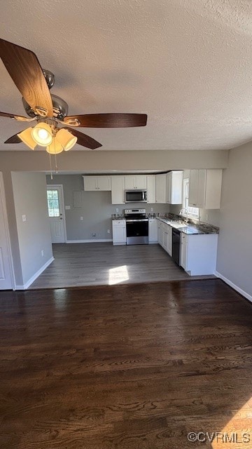 kitchen featuring a textured ceiling, white cabinetry, ceiling fan, stainless steel appliances, and dark hardwood / wood-style floors