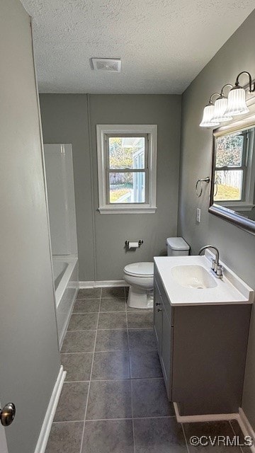 bathroom with vanity, toilet, a textured ceiling, and tile patterned flooring