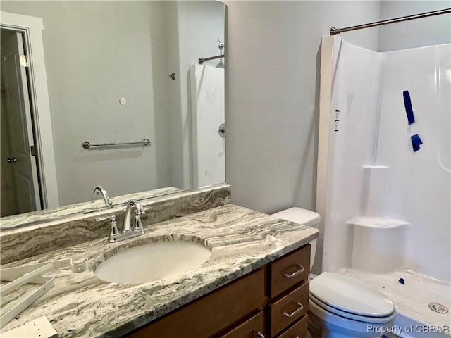 bathroom featuring walk in shower, vanity, and toilet