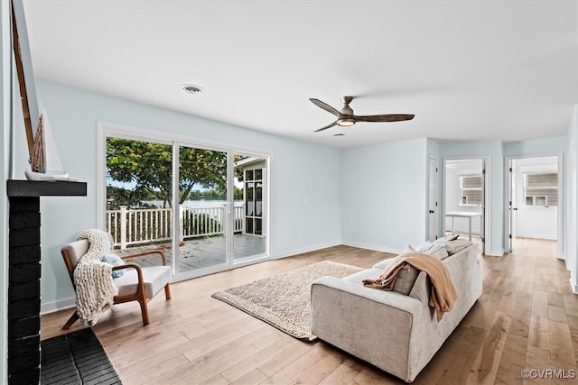 living room featuring ceiling fan and light hardwood / wood-style flooring