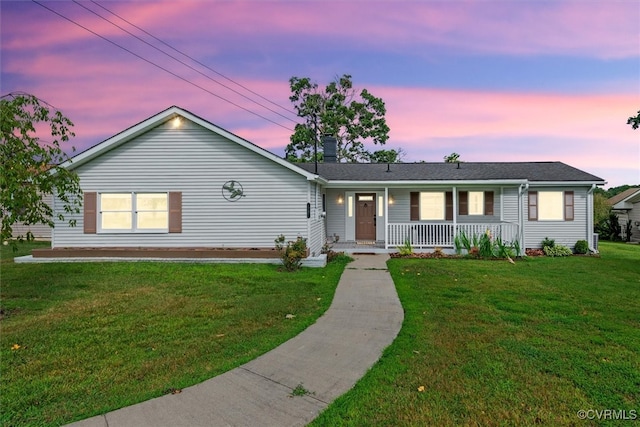 single story home featuring a yard and covered porch