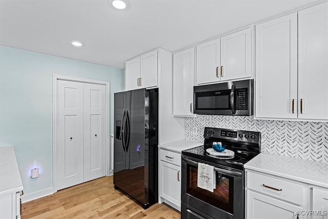 kitchen featuring tasteful backsplash, appliances with stainless steel finishes, light hardwood / wood-style flooring, and white cabinets