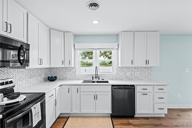 kitchen with light hardwood / wood-style flooring, stainless steel appliances, sink, and white cabinets